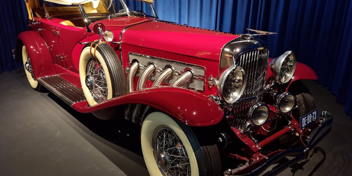 Duesenberg SJ roșu cu plafon crem și evacuări exterioare la Louwman Museum