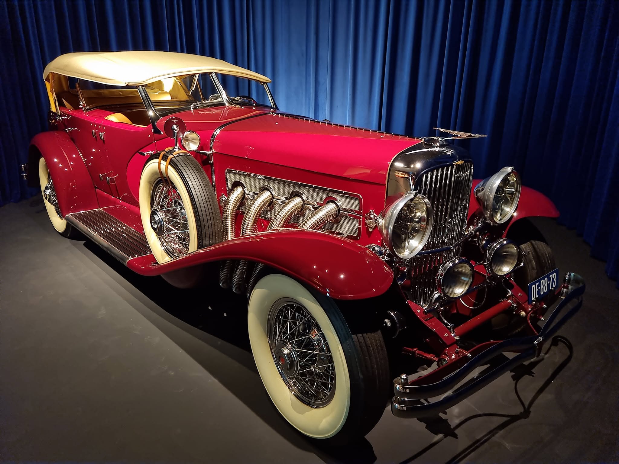 Duesenberg SJ roșu cu plafon crem și evacuări exterioare la Louwman Museum