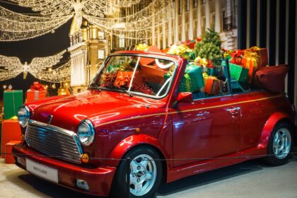 Mini Cabriolet clasic roșu cu pachete decorative și lumini de sărbătoare